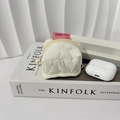 Close-up of white quilted storage pouch with pearl zipper and pink rabbit label - White