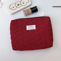 Macro detail of red quilted heart pattern on large vanity bag with metal zipper - Red