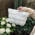 Detail of white quilted nylon makeup bag with gold zipper and MAY RABBIT woven label - White Quilted