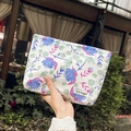 Détail de la trousse à maquillage fleurie avec motifs bleus et étiquette May Rabbit - Floral Bleu