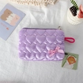 Close-up of purple quilted pouch with heart patterns and a pink checkered bow detail - Purple
