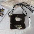 Close-up of brown plush crossbody bag featuring floral patterns and woven strap detail - Plush Coffee Floral