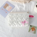 Detail of white heart-quilted storage pouch with pink bow and satin finish texture - White