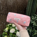 Roze geruit etui met blauwe strikjes en geweven label in een tuin in de buitenlucht - Rood