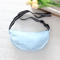 Top view of a light blue dumpling bag with a striped adjustable shoulder strap on white fabric - Blue