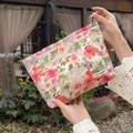 Détail de la trousse de maquillage florale avec motif fleurs roses et étiquette tissu - Été Coloré