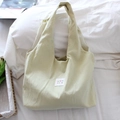 Détail du sac cabas en toile beige à pois noirs et étiquette en tissu Mayrabbit - Petit Pois Jaune Clair