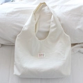 Détail du cabas en toile beige à pois noirs avec étiquette de logo mayrabbit - Petit Pois Blanc Cassé