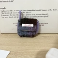 Detail van handgebreid pluche oortelefoonzakje in paars verloop met Mayrabbit-logo - Korte Koord Gebreid Paars Bruin Grijs Gradiënt