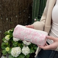 Close-up of floral makeup bag with pink flower pattern and zipper held by hand outdoors - Pink Rose