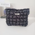 Detailed close-up of black quilted nylon bag featuring a Mat Rabbit brand woven label - Wrinkle Black Grid