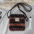 Close-up of plush crossbody bag with colorful geometric patterns and fabric brand label - Plush Orange Blue Stripes