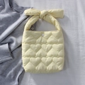 Détail du sac matelassé à motifs cœurs jaune clair avec une grande anse en nœud - Jaune