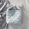 Détail du sac à main bleu clair matelassé en cœur avec poignée nœud et texture souple - Bleu clair