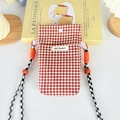 Detail of red checkered canvas phone bag with orange rope strap and logo label - Red Plaid