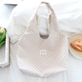 Close-up of heart print canvas tote bag featuring a white square woven brand label - Off-White with Red Hearts