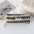 Dettaglio dell'astuccio in morbido peluche a righe ondulate con etichetta May Rabbit - Pile a Righe Blu Marrone
