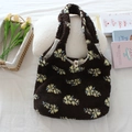 Detailed view of plush tote bag with yellow floral pattern and metal button closure - Plush Coffee Floral