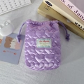 Vue rapprochée du motif de cœur matelassé violet sur la pochette de rangement en satin - Violet