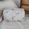 Close-up of quilted cotton cosmetic bag featuring blue stripes and cute cartoon bear pattern - Bear
