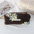 Macro shot of soft brown plush flower pencil case with May Rabbit label on fabric - Plush Coffee Floral