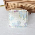 Detail of square floral pouch with butterfly print on pleated beige fabric texture - Colorful Butterfly