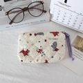 Detail of quilted cotton dog print makeup bag with purple zipper strap and brand label - Beige Dog