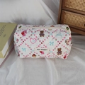 Close-up of white quilted cosmetic bag with pink floral and cute cartoon animal prints - Dessert Rabbit