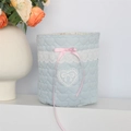 Détail du panier en tissu bleu matelassé cœur avec bordure dentelle et nœud rose - Cœur en Crêpe Bleu