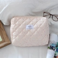Nahaufnahme der rosa gesteppten Kosmetiktasche mit Hasen- und Erdbeermuster - Rosa Erdbeer-Hase