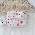 Close-up of quilted floral coin purse with red strawberry and dog prints on white fabric - Pink Rabbit