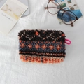 Detail of plush cosmetic bag with colorful geometric patterns and pink handle - Plush Orange Blue Stripes