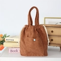 Detailed close-up of brown corduroy tote bag with drawstring closure and blue button - Brown