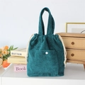 Detail of dark green corduroy drawstring handbag with front pocket and button closure - Dark Green