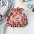 Detalle de bolsa de cuadros rojos con cordón, bordes con volantes y auriculares decorativos - Cuadros Rojos