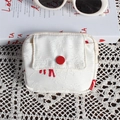 Detail van een witte jacquard mini-tas met rode knoopsluiting op een kant tafelkleed - Witte Achtergrond Rood Paard