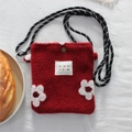 Detailed macro view of red plush crossbody bag featuring white flower patches and woven strap - Flower / Red