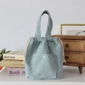 Close-up of light blue corduroy tote bag featuring a front pocket and cotton drawstring detail - Light Blue Grey