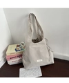 Detail view of beige nylon tote bag featuring side drawstrings and minimalist woven label - Nylon Grey With Ties