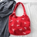 Dettaglio borsa tote in maglia rossa con ricamo a fiocco bianco e trama invernale - Fiocco Grande Rosso Vero