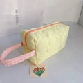 Dettaglio della trousse gialla trapuntata con manici rosa e chiusura lampo a contrasto - Trapuntato a Nuvola (Giallo) / Giallo