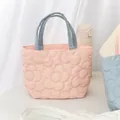 Close-up of floral quilted handbag with pink fabric and blue contrasting handles - Pink