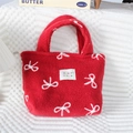 Detail of red plush tote bag with white bow embroidery and high-quality stitched label - Large Bow True Red