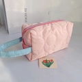 Pink quilted floral makeup bag with blue handle and floral stitching pattern - Pink