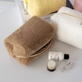Detailed view of colorful plush cosmetic bags in soft brown, white, yellow and pink faux fur - Brown