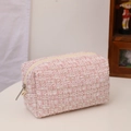 Detail van roze en witte tweed-stoftextuur op een chique draagbare make-uptas - Tweed Roze