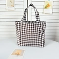 Detail shot of a black and white checkered canvas tote bag with dual top handles - Big Brown Grid