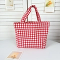 Close-up of red and white gingham canvas tote bag on a minimalist white table - Red Plaid