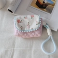 Detail view of quilted floral camera case with blue pom-poms and woven handle strap - Crepe Striped Heart Light Pink