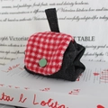 Detailaufnahme der Mini-Tasche mit rot-weiß karierter Klappe und grünem Knopf-Akzent - Schwarzer Jeans Rot Kariert